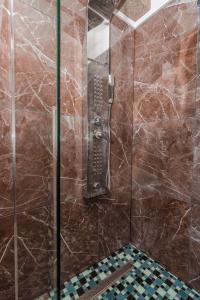 uma casa de banho com um chuveiro e uma porta de vidro em SALONA HILLS with magical view of SPLIT em Solin
