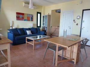 sala de estar con sofá azul y mesa en Villa 3Ω en Nea Skioni