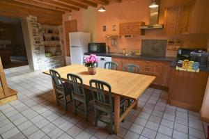 a large kitchen with a wooden table and chairs at Gite Le Douglas, Vignoble et Reculées du Jura - Avec Sauna in Lavigny
