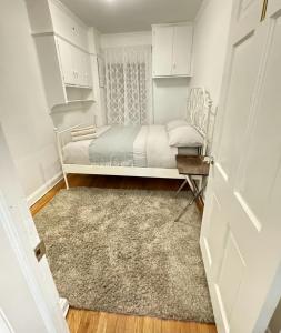 ein kleines Schlafzimmer mit einem Bett und einem Teppich in der Unterkunft Stay Rego Park in Rego Park