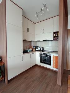 a white kitchen with white cabinets and appliances at Apartmani Seaside in Dobra Voda