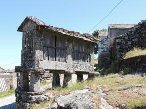 un antiguo edificio de piedra con una ventana en una colina en Casa do Forno en Mondim de Basto
