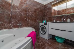 uma casa de banho com uma banheira e uma máquina de lavar roupa em SALONA HILLS with magical view of SPLIT em Solin