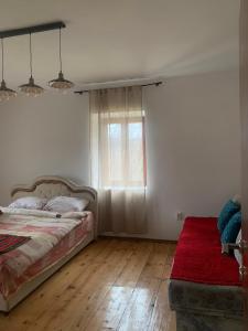 a bedroom with a bed and a window and a red rug at Ethno guesthouse Tara in Mojkovac