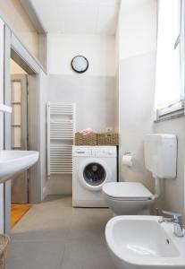 bagno bianco con lavatrice e servizi igienici di Casa Parravicini a Sondrio
