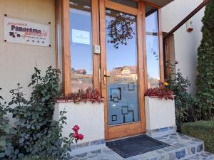 una puerta a un edificio con flores delante en Pension Panorama, en Odorheiu Secuiesc