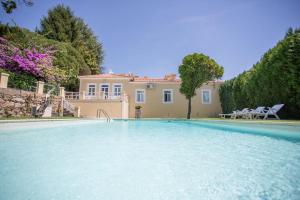 a large swimming pool in front of a house at Glicínia Boutique Hotel in Freamunde