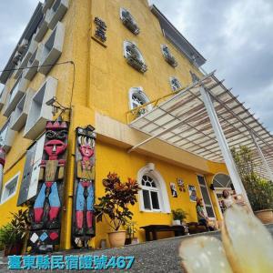 un edificio amarillo con pinturas al costado. en Cheng-Ping Hot Spring Inn, en Wenquan