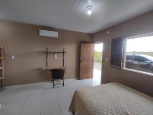 a bedroom with a bed and a desk and a window at Taíba Downwind House in São Gonçalo do Amarante