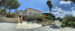 une maison avec un palmier et une allée dans l'établissement Hôtel Jas Neuf, à Sainte-Maxime
