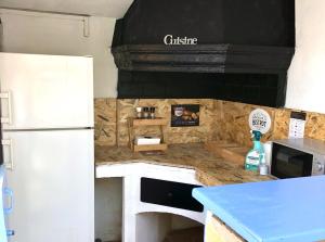 a kitchen with a counter top and a refrigerator at Hôtel Jas Neuf in Sainte-Maxime