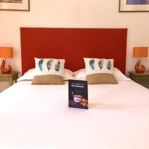 a book sitting on top of a bed at Hôtel Jas Neuf in Sainte-Maxime