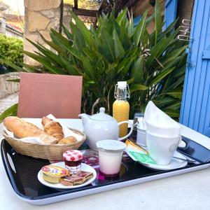 ein Tablett mit Brot und Kaffee auf dem Tisch in der Unterkunft Hôtel Jas Neuf in Sainte-Maxime