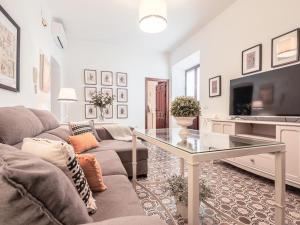 ein Wohnzimmer mit einer Couch und einem Glastisch in der Unterkunft Descanso y paz en la Juderia de Carmona in Carmona