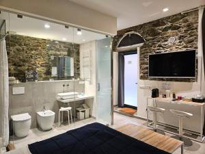 a bathroom with a bed and a tv on a wall at ca' di sotto in Riomaggiore