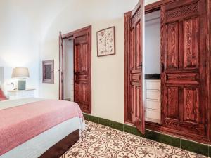 um quarto com uma cama e um grande armário de madeira em Descanso y paz en la Juderia de Carmona em Carmona