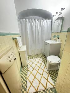 uma casa de banho com um WC branco e um lavatório. em Stay Rego Park em Rego Park