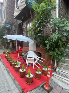 un tappeto rosso con tavolo, sedie e ombrellone di Nuray Hotel a Istanbul