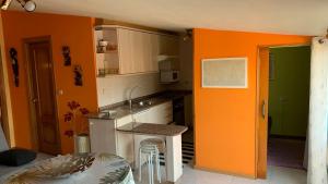 a kitchen with orange and green walls and a counter at Precioso ático en Playa América a 200 metros de la playa in Nigrán
