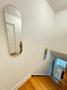 einen Spiegel an der Wand eines Zimmers mit einer Treppe in der Unterkunft Stay Rego Park in Rego Park