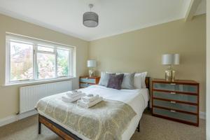 een slaapkamer met een bed met twee handdoeken erop bij Lovely 2BR in peaceful Hampstead, NW London in Londen