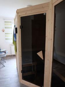 eine große Glastür in einem Zimmer mit einer Holzwand in der Unterkunft Ferienhaus am Wald mit Sauna in Bad Elster