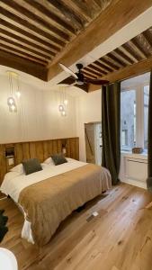a bedroom with a large bed with a ceiling fan at Les Balcons de Guignol in Lyon