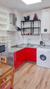 een keuken met rode kasten en een wasmachine bij BENALBEACH RESORT NEW APARTMENT - Benalmádena Málaga in Benalmádena