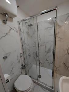 a bathroom with a shower and a toilet and a sink at Hotel Positano Suite in Rome