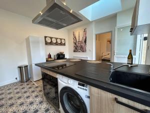 a kitchen with a washing machine and a sink at Le Traveller - COSY FLAT Senlis in Senlis