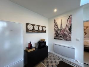 a living room with a coffee table and clocks on the wall at Le Traveller - COSY FLAT Senlis in Senlis