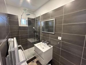 a bathroom with a white sink and a mirror at Le Traveller - COSY FLAT Senlis in Senlis