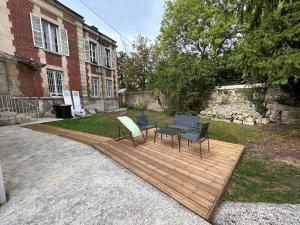 a group of chairs and a table on a wooden deck at Le Traveller - COSY FLAT Senlis in Senlis +11 photos