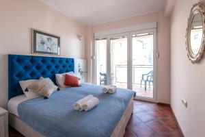 een slaapkamer met een blauw bed en handdoeken bij Mila & Aleksandr Apartments in Budva