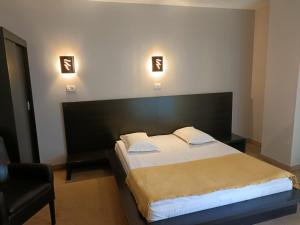 1 dormitorio con 1 cama grande y 1 silla en Hotel Maxim, en Arad