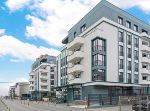 um grande edifício branco numa rua da cidade em My Place Residence em Voluntari