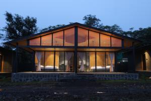 a house with large glass windows on the side of it at Shreephal luxurious Resort- Best resort in saputara in Saputara