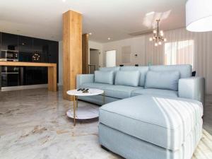 een woonkamer met een blauwe bank en een tafel bij Sea La Vie House - Privat Pool & Luxurious & Top View & Albufeira in Albufeira