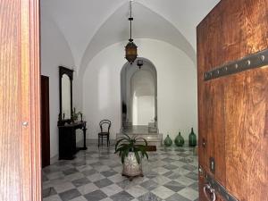 un corridoio con tavolo e vaso con pianta di Relais - Galleria Gagliardo a Polizzi Generosa