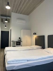 um quarto com três camas e uma cozinha em Apartment Loftas13-6 em Kretinga