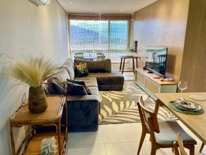 ein Wohnzimmer mit Sofa und Tisch in der Unterkunft Camburizinho 3 suítes Beach Tenis in São Sebastião