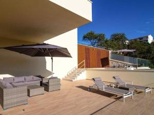 阿爾布費拉的住宿－Sea La Vie House - Privat Pool & Luxurious & Top View & Albufeira，天井配有沙发、椅子和遮阳伞