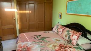 a bedroom with a bed with flowers on it at Precioso ático en Playa América a 200 metros de la playa in Nigrán