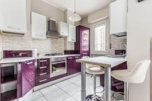a kitchen with purple cabinets and a table in it at Smart Stay Milano - apartment free wifi fibra - Policlinico San Donato - in San Donato Milanese +9 photos