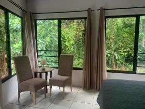 a bedroom with a bed and a table and chairs at Casa Palmera Cocles, 300m to the beach in Puerto Viejo