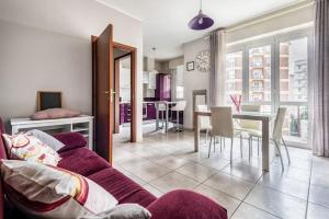 uma sala de estar com um sofá roxo e uma sala de jantar em green oasis in milan - luxury appartment free wifi - Policlinico San Donato em San Donato Milanese