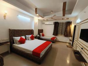 a bedroom with a bed and a couch and a television at Hotel Omni Plaza in Jodhpur