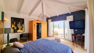 a bedroom with a blue bed and a television at Sapore di mare Luxury B&B and Cooking in Marbella