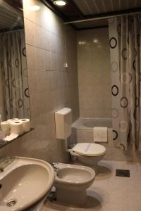 a bathroom with a toilet and a sink and a tub at Garni Hotel Jugoslavija in Belgrade