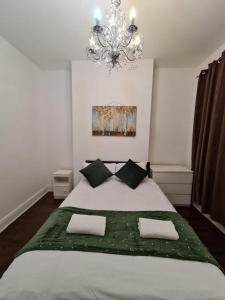 a bedroom with a large white bed with a chandelier at Canary Wharf Home stay in London